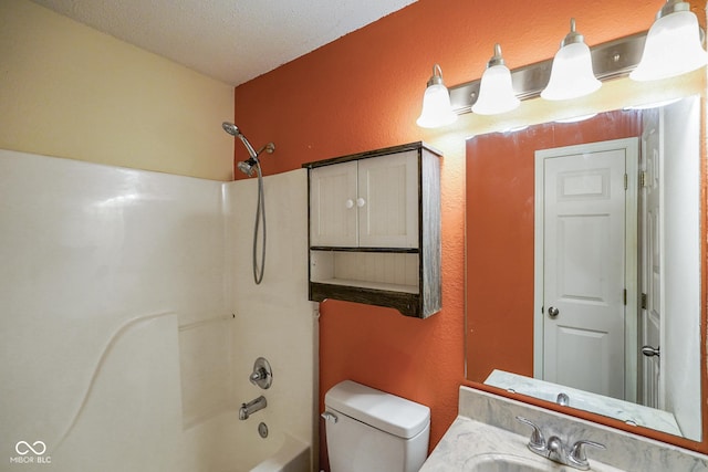 full bathroom featuring a textured wall, toilet, tub / shower combination, a textured ceiling, and vanity