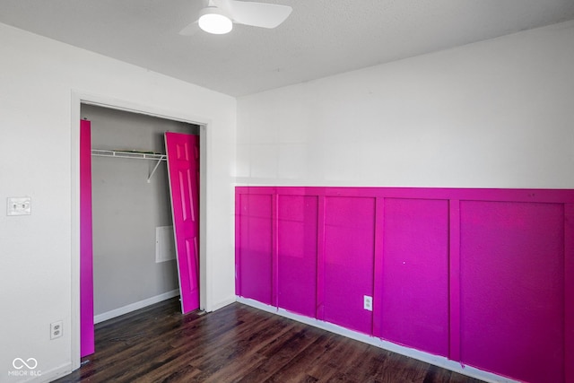 unfurnished bedroom featuring a ceiling fan, a closet, baseboards, and wood finished floors