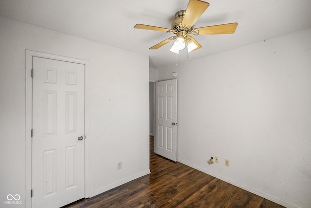 unfurnished bedroom with a ceiling fan, dark wood finished floors, and baseboards