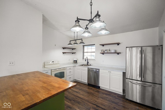 kitchen featuring white cabinets, dark wood-style floors, appliances with stainless steel finishes, open shelves, and a sink