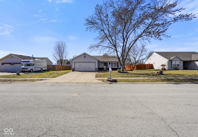 view of front of home with a garage, driveway, a front lawn, and fence