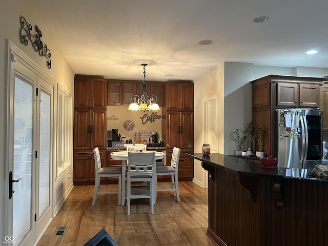 dining room with a chandelier, wood finished floors, and visible vents