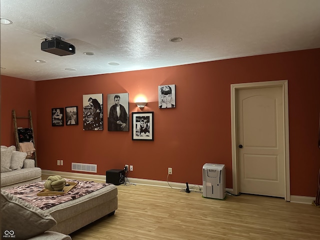 home theater featuring light wood-style flooring, visible vents, and baseboards