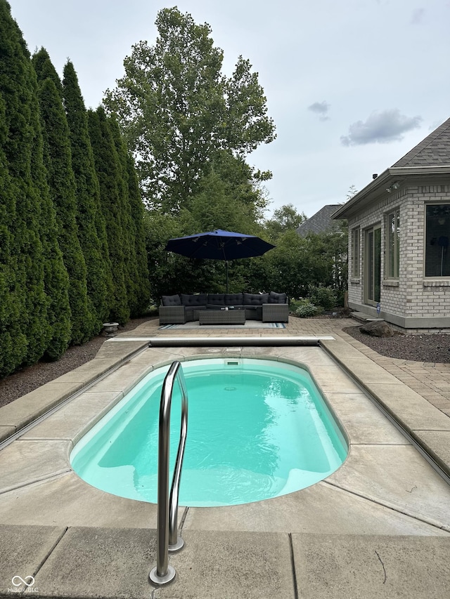 pool with a patio area and an outdoor living space