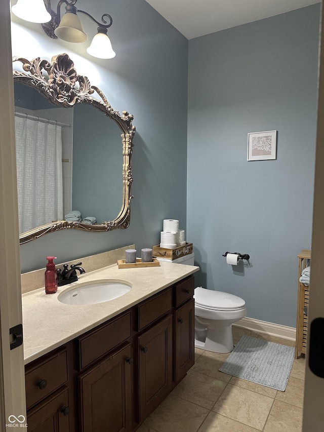 full bathroom featuring toilet, tile patterned flooring, baseboards, and vanity