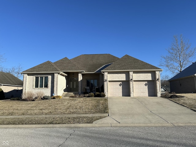 view of front facade featuring an attached garage, roof with shingles, concrete driveway, and brick siding