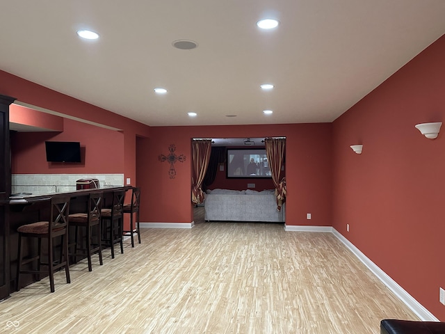 bar with baseboards, wood finished floors, and recessed lighting