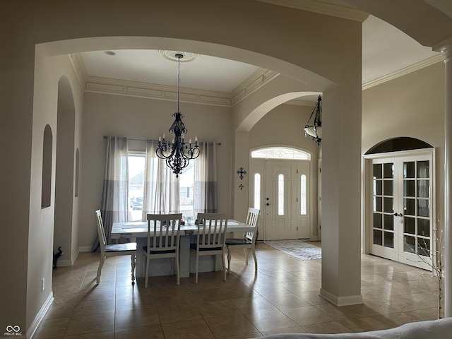 tiled dining area featuring baseboards, an inviting chandelier, and crown molding