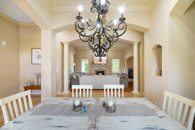 286 S Woodridge Dr, Pittsboro, IN 46167 - dining area featuring a chandelier, ornamental molding, a lit fireplace, ornate columns, and arched walkways