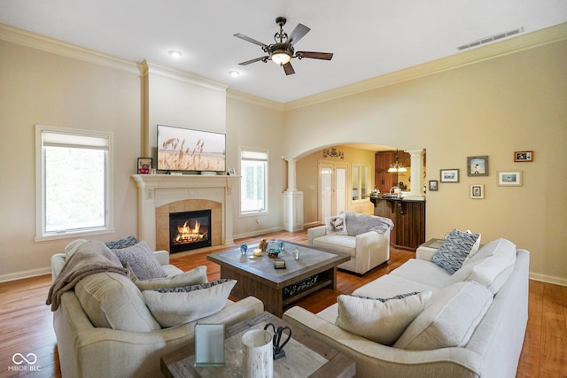 286 S Woodridge Dr, Pittsboro, IN 46167 - living room featuring arched walkways, a ceiling fan, a tile fireplace, baseboards, and ornamental molding