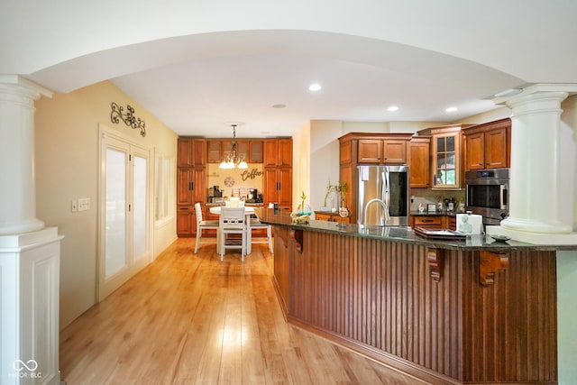 286 S Woodridge Dr, Pittsboro, IN 46167 - kitchen featuring appliances with stainless steel finishes, brown cabinetry, ornate columns, a kitchen breakfast bar, and recessed lighting