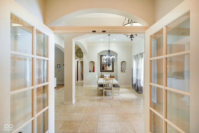 286 S Woodridge Dr, Pittsboro, IN 46167 - dining area with a chandelier, arched walkways, crown molding, french doors, and light tile patterned floors