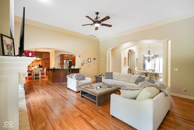 286 S Woodridge Dr, Pittsboro, IN 46167 - living room with arched walkways, ceiling fan, crown molding, light wood-style floors, and a chandelier