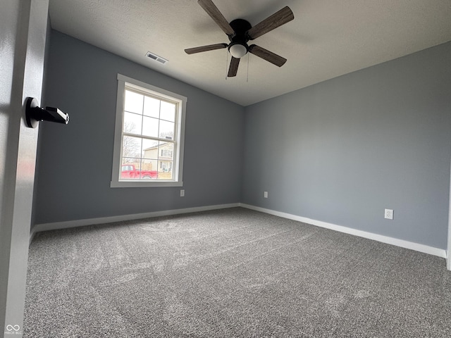 carpeted empty room featuring visible vents, ceiling fan, a textured ceiling, and baseboards