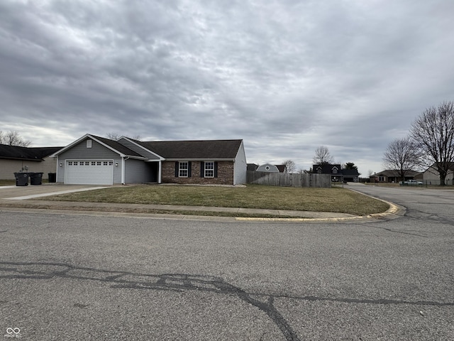 view of front of home with a garage, brick siding, fence, concrete driveway, and a front yard