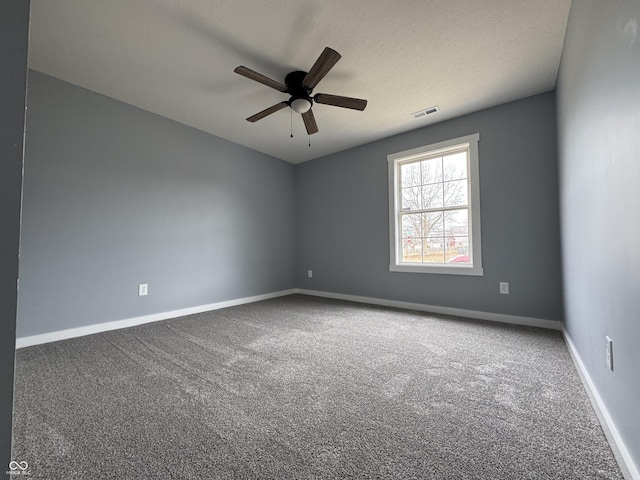 carpeted empty room with a textured ceiling, a ceiling fan, visible vents, and baseboards