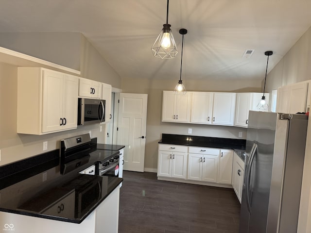 kitchen with visible vents, lofted ceiling, dark countertops, stainless steel appliances, and white cabinetry