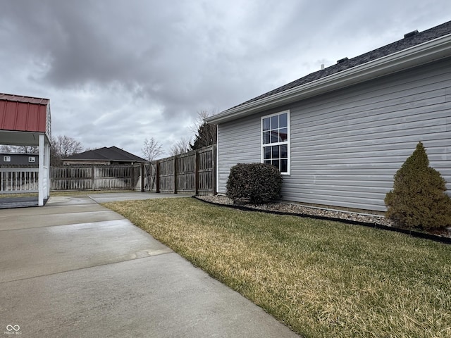 view of side of home featuring a yard and fence