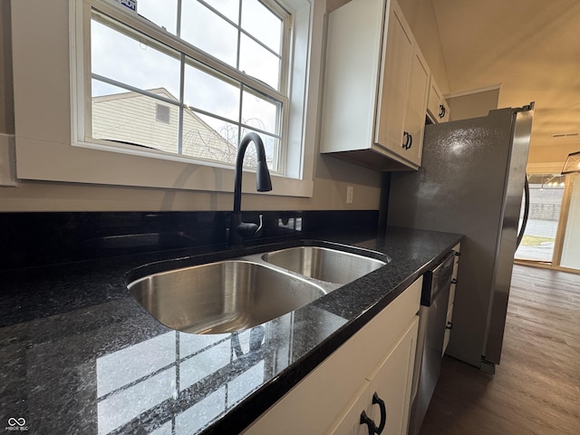 kitchen with stainless steel appliances, wood finished floors, a sink, and a healthy amount of sunlight