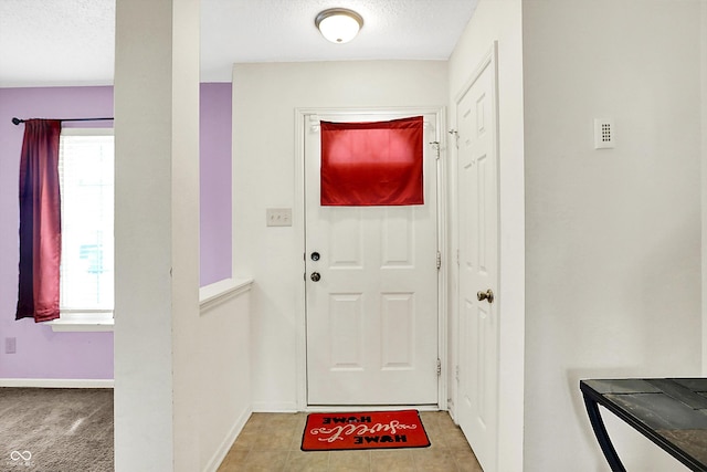 entryway featuring a textured ceiling and baseboards