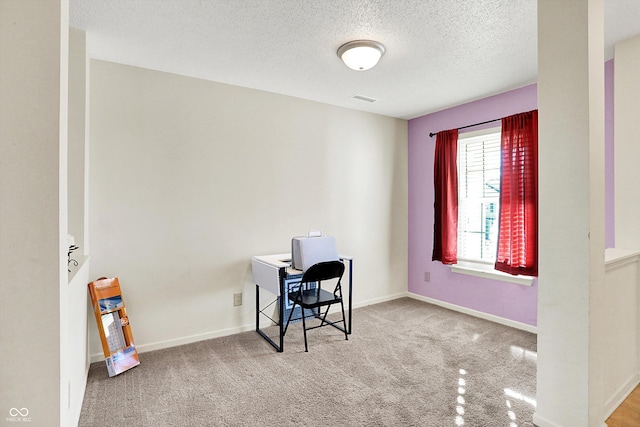 home office featuring baseboards, a textured ceiling, visible vents, and carpet flooring