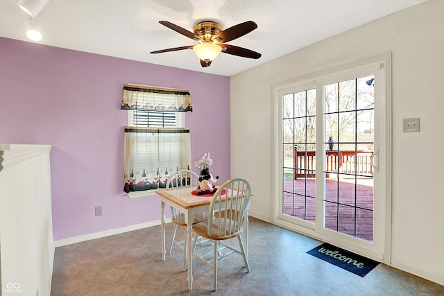 dining area featuring ceiling fan and baseboards