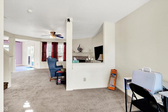 interior space with a textured ceiling, carpet flooring, a ceiling fan, baseboards, and stairs