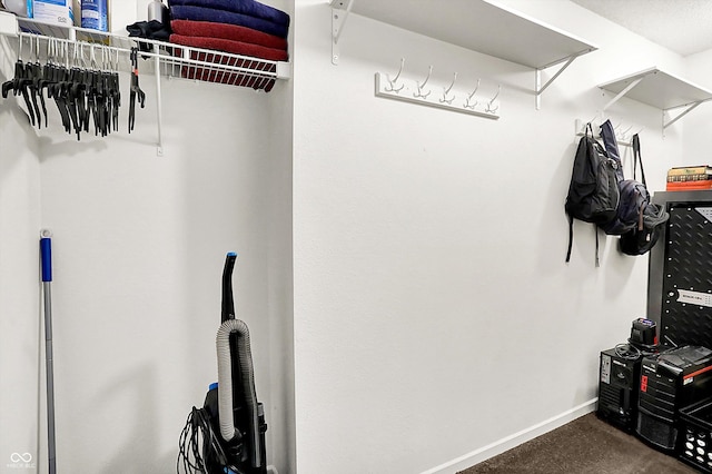 spacious closet featuring dark carpet