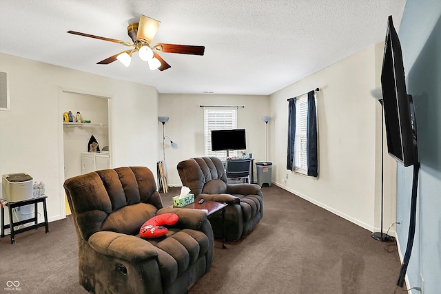 living room with dark carpet, a textured ceiling, washing machine and clothes dryer, and ceiling fan