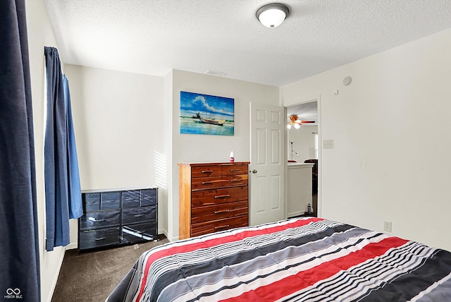 bedroom with carpet floors, visible vents, and a textured ceiling