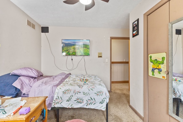 bedroom with baseboards, visible vents, a ceiling fan, a textured ceiling, and carpet flooring