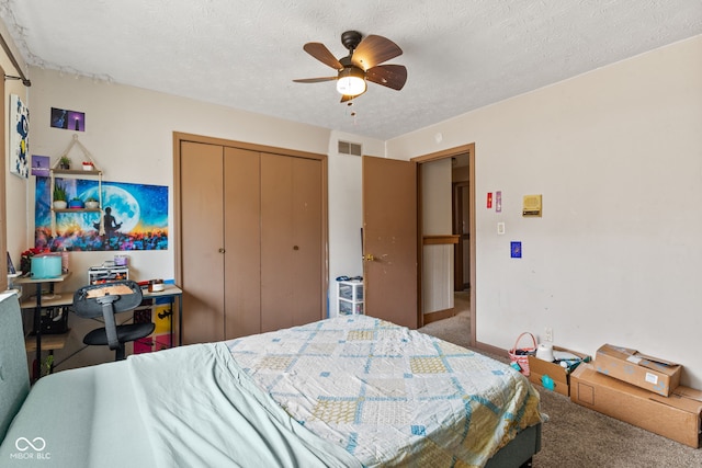 bedroom featuring a textured ceiling, ceiling fan, carpet flooring, visible vents, and a closet