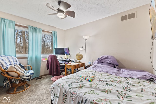 bedroom with a ceiling fan, carpet, visible vents, and a textured ceiling