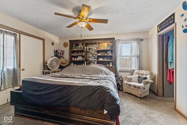 carpeted bedroom featuring a textured ceiling, baseboards, and a ceiling fan