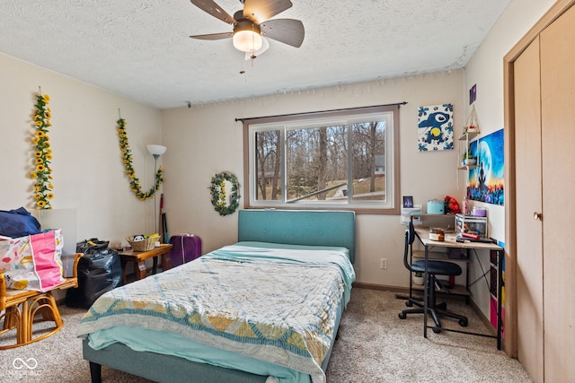 bedroom featuring carpet floors, a textured ceiling, baseboards, and a ceiling fan