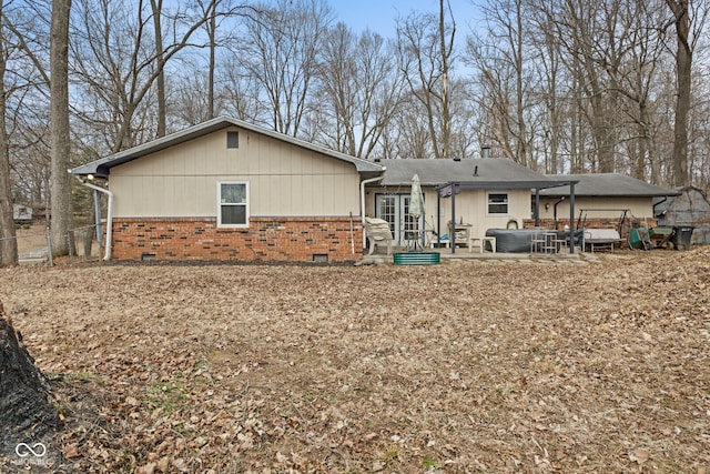 back of house with crawl space, brick siding, a patio, and fence