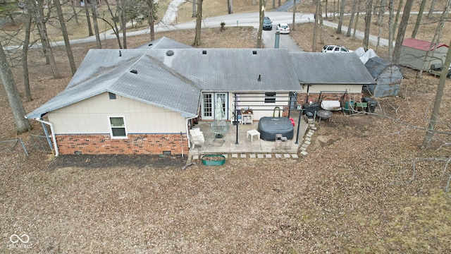 rear view of property with brick siding and a patio