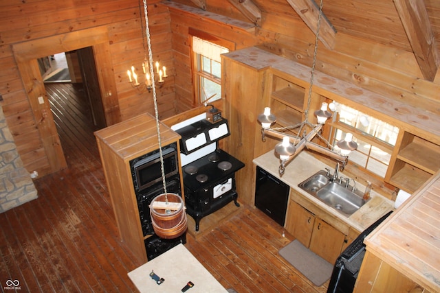 kitchen featuring dark wood-style flooring, wood walls, a sink, and an inviting chandelier