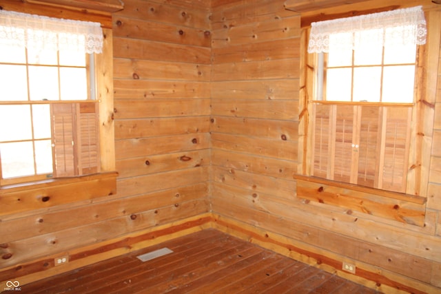 spare room featuring a sauna, wood walls, and plenty of natural light