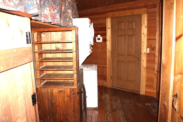 interior space featuring hardwood / wood-style flooring, wooden walls, and washer / clothes dryer