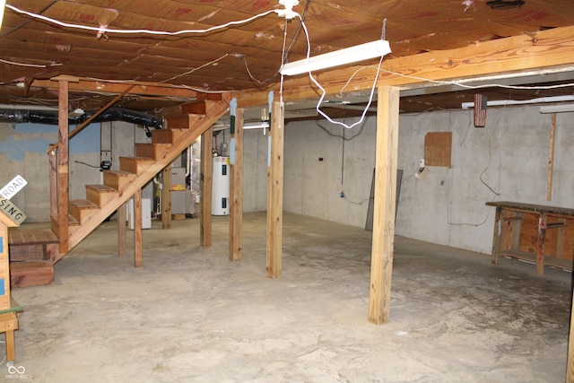 unfinished basement with electric water heater and stairs