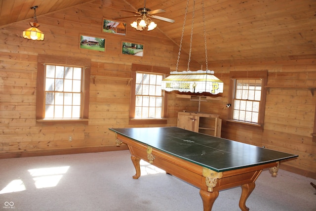 recreation room with lofted ceiling, carpet, a wealth of natural light, and wooden walls