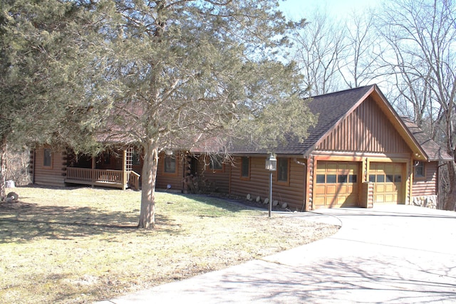 view of front of home featuring an attached garage, a front lawn, concrete driveway, and roof with shingles