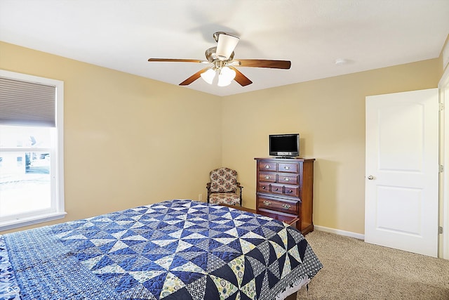 bedroom with ceiling fan, baseboards, and light colored carpet