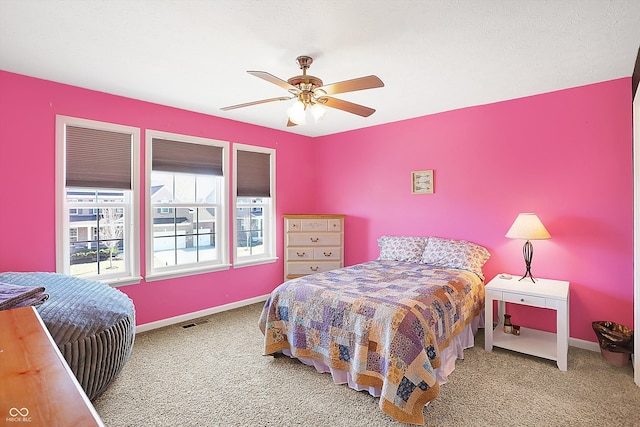 bedroom featuring ceiling fan, carpet floors, visible vents, and baseboards