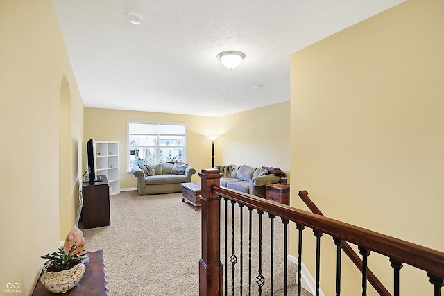 carpeted living room with a textured ceiling and baseboards