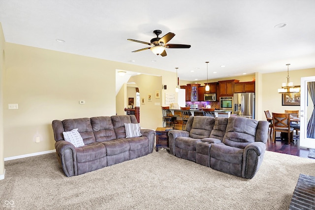 living room featuring recessed lighting, baseboards, and ceiling fan with notable chandelier