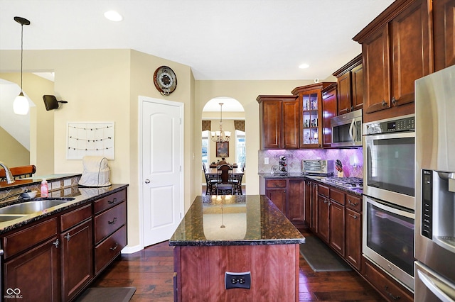 kitchen with dark wood-style floors, backsplash, stainless steel appliances, and a sink