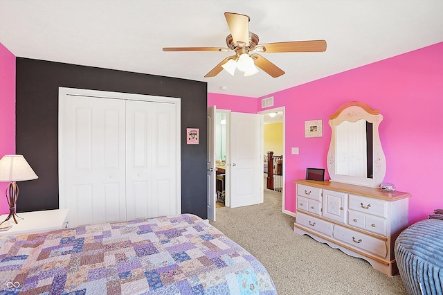 carpeted bedroom featuring ceiling fan, visible vents, and a closet