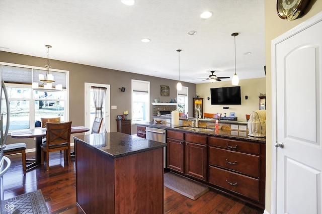 kitchen featuring stainless steel dishwasher, dark wood finished floors, open floor plan, and a sink